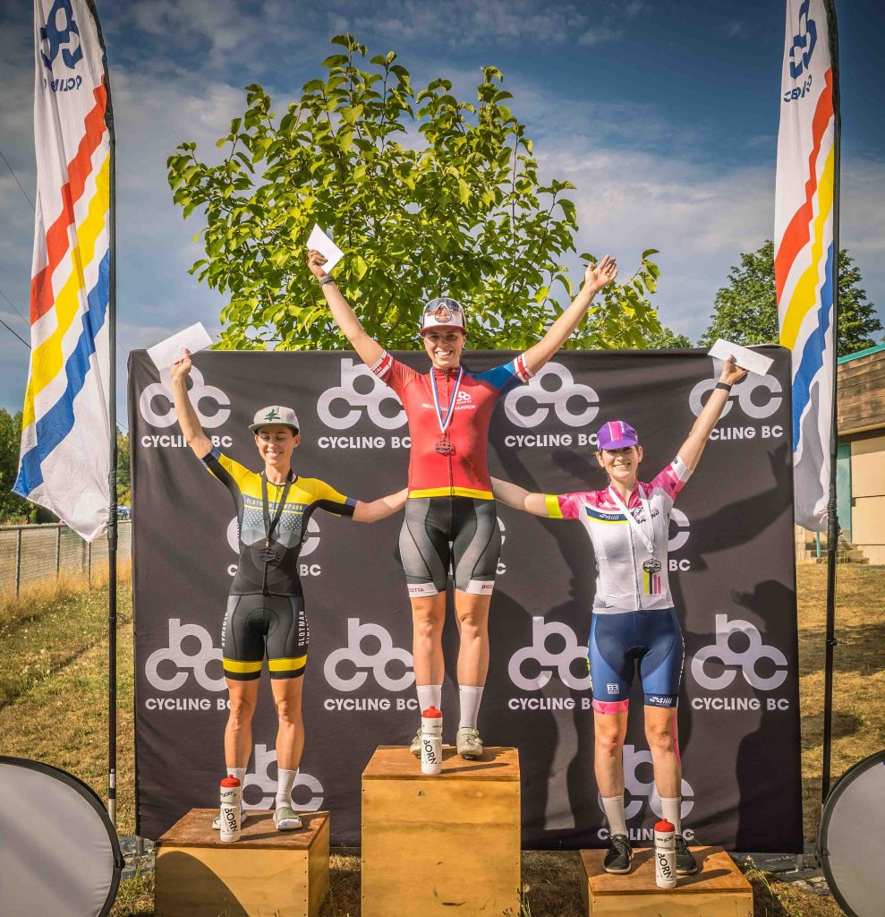 Elite women racers stand on the awards podium for a photo