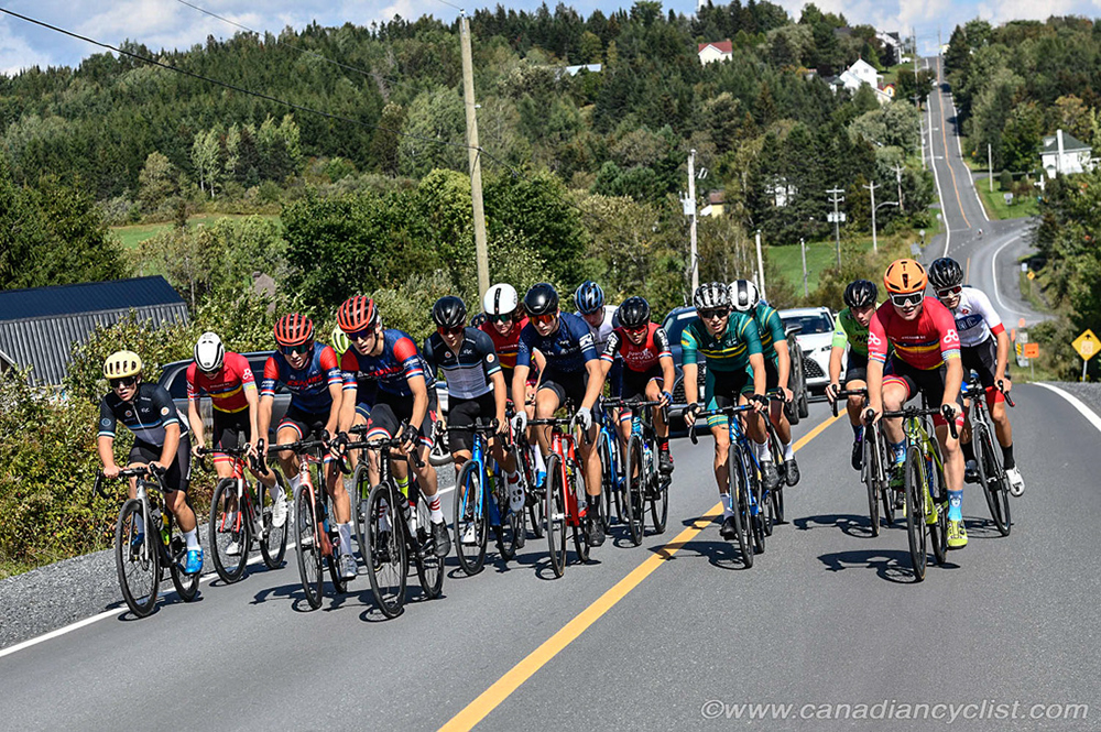 Men's Peloton on the road with trees and open road in the background