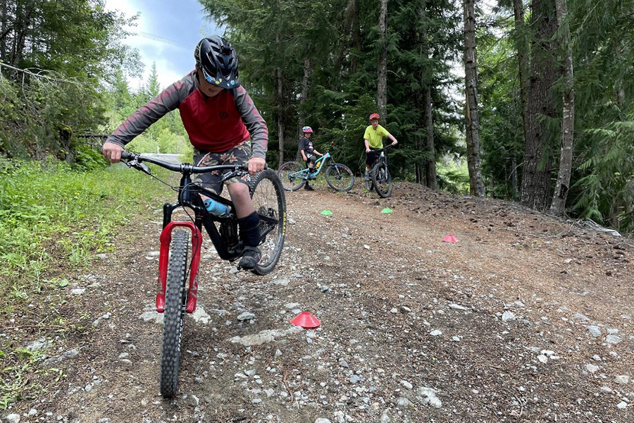 Young mountain biker practicing a cornering drill on the trail