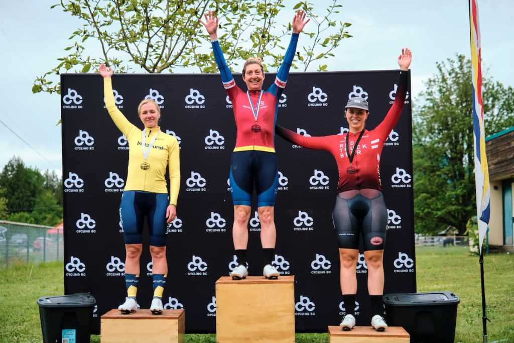 Top three winners on the awards podium with a Cycling BC backdrop