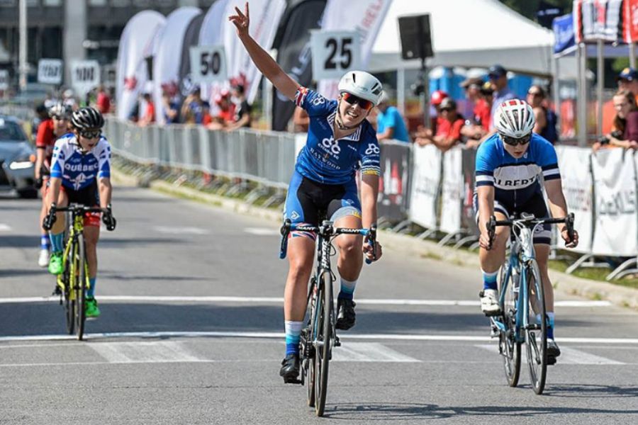 Road cyclists crossing a finish line.