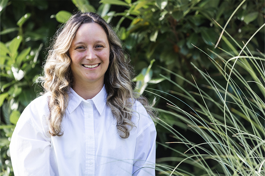 Woman wearing white button up, smiling