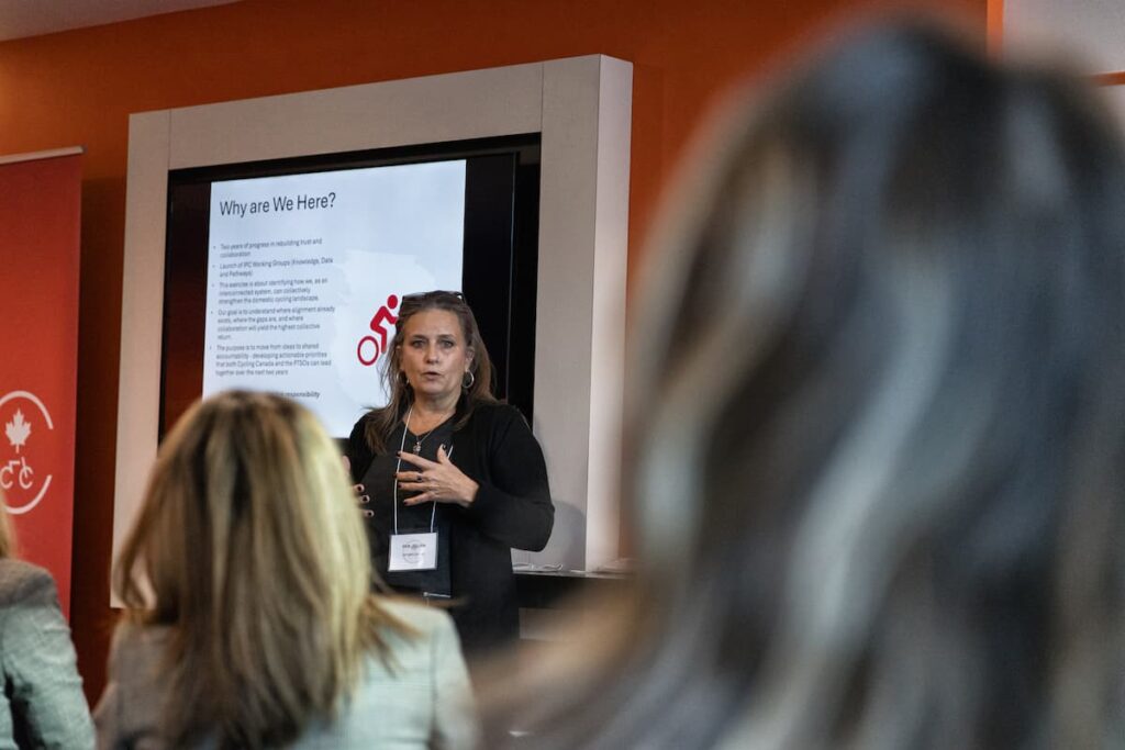 Woman presenting in front of a projection screen.