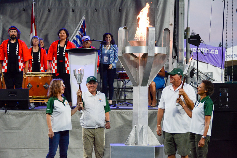 A group of people around a lit ceremonial torch for the Games