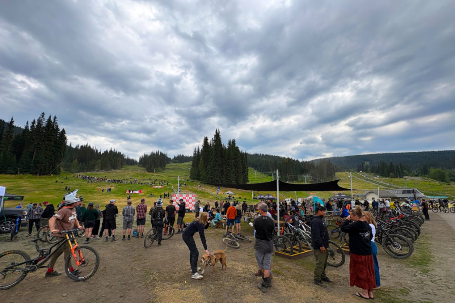 A crowd gathered at the bottom of a mountain bike race track.